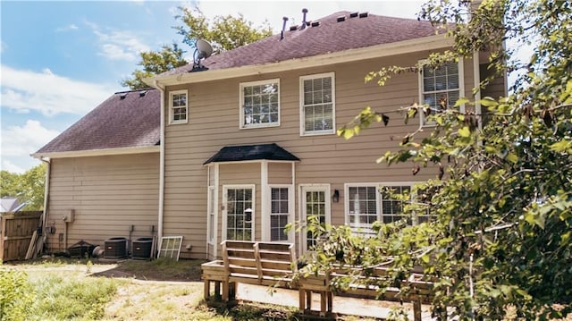 back of house featuring fence, roof with shingles, and central air condition unit