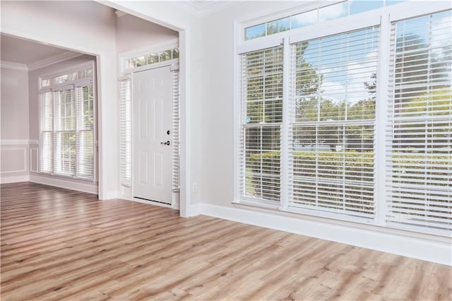 foyer featuring ornamental molding, wood finished floors, and baseboards