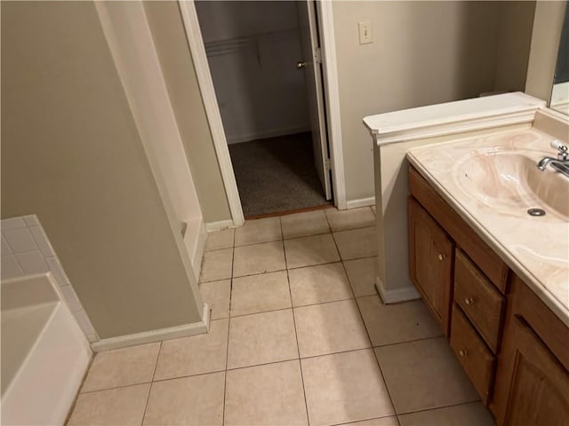 full bath featuring a tub, tile patterned flooring, vanity, and a spacious closet