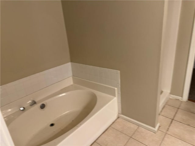 full bath with tile patterned flooring, a garden tub, and baseboards