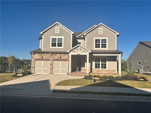 craftsman-style home with central air condition unit, a garage, and a front yard