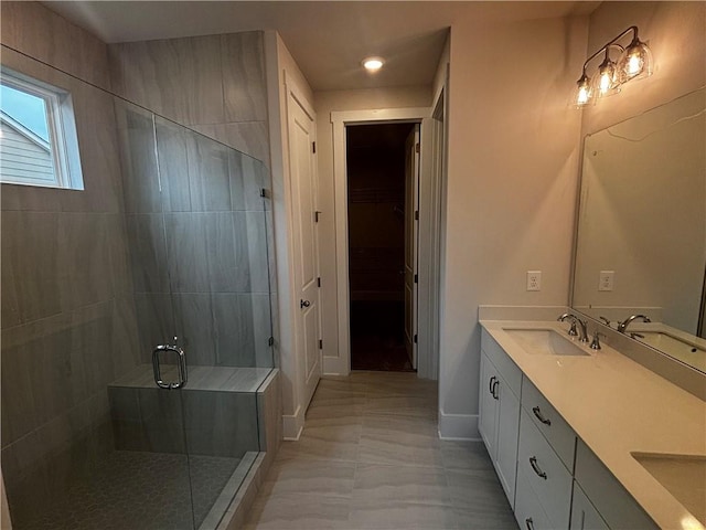 bathroom with vanity and a shower with door