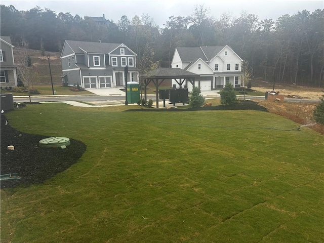 view of yard featuring a garage, central AC unit, and a gazebo