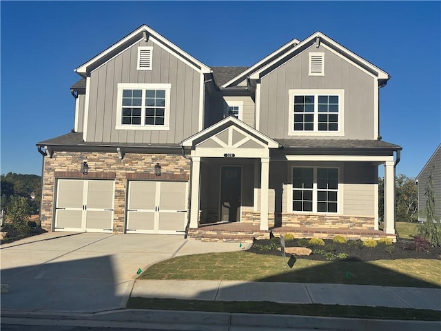 328 Willow Cv, Canton, GA 30114 - craftsman house featuring stone siding, a garage, concrete driveway, board and batten siding, and a front yard