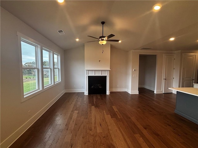 unfurnished living room featuring ceiling fan, dark hardwood / wood-style floors, and vaulted ceiling