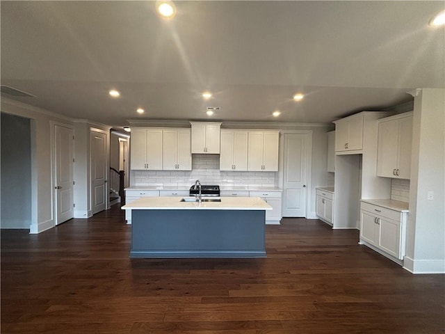 kitchen featuring white cabinets, a kitchen island with sink, dark hardwood / wood-style flooring, and tasteful backsplash