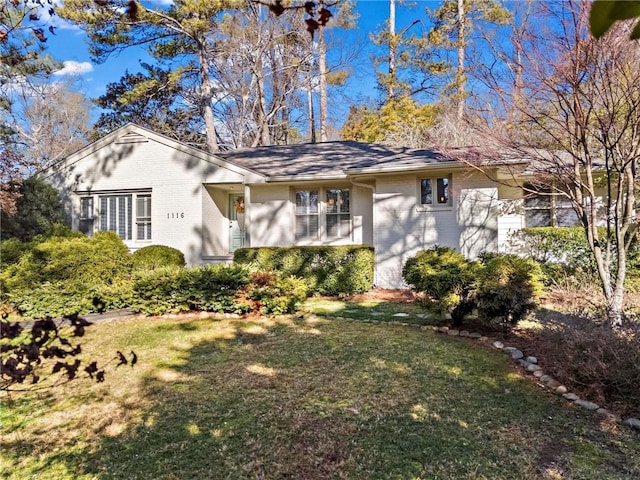 view of front facade with brick siding and a front lawn