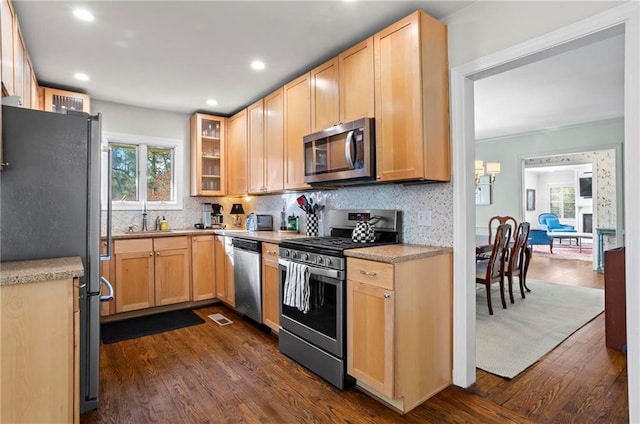 kitchen with glass insert cabinets, dark wood-style floors, appliances with stainless steel finishes, and light countertops