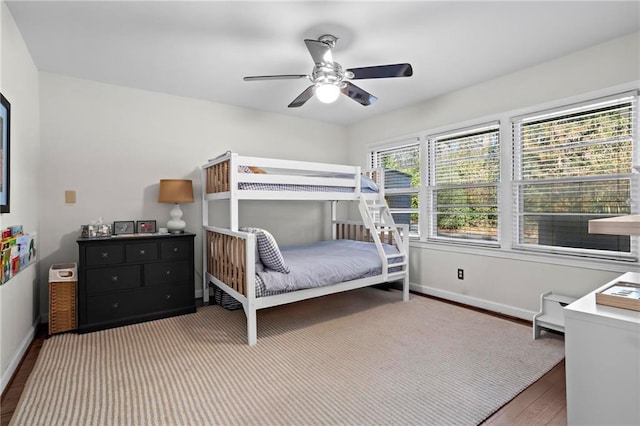 bedroom featuring a ceiling fan, baseboards, and dark wood-type flooring