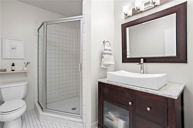 bathroom featuring a stall shower, vanity, toilet, and tile patterned floors