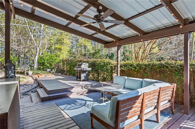 wooden deck with ceiling fan, fence, area for grilling, and an outdoor hangout area