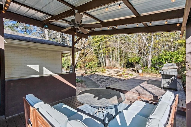 wooden terrace with a ceiling fan, a grill, and an outdoor living space