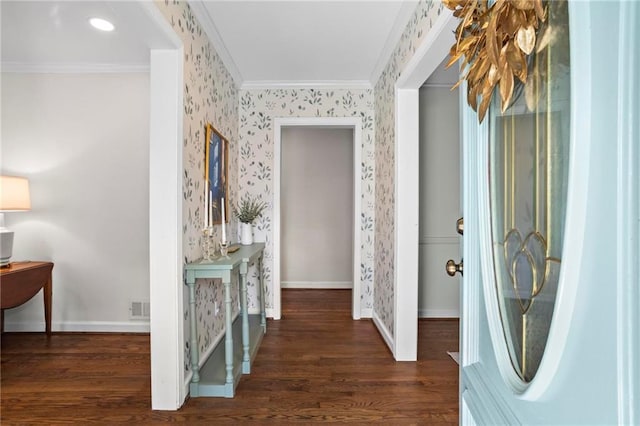 foyer entrance featuring dark wood-style floors, baseboards, ornamental molding, and wallpapered walls