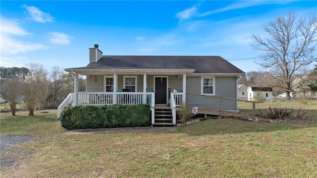 view of front of house with a chimney, a porch, and a front lawn