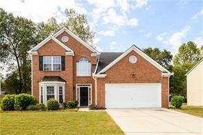 2715 Haynes Club Cir, Grayson, GA 30017 - view of front facade with driveway, a front yard, and a garage