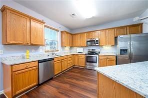 2715 Haynes Club Cir, Grayson, GA 30017 - kitchen with appliances with stainless steel finishes, dark wood finished floors, light countertops, and a sink