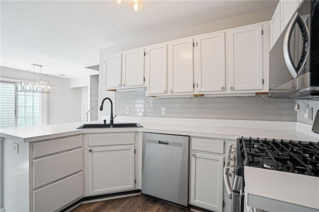 1822 Commonwealth Dr, Woodstock, GA 30188 - kitchen featuring appliances with stainless steel finishes, a peninsula, light countertops, white cabinetry, and decorative backsplash