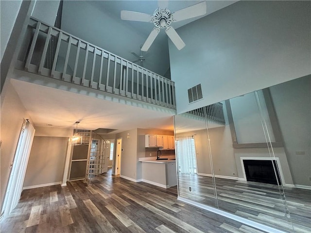 1822 Commonwealth Dr, Woodstock, GA 30188 - unfurnished living room featuring a ceiling fan, a sink, dark wood-type flooring, baseboards, and a towering ceiling