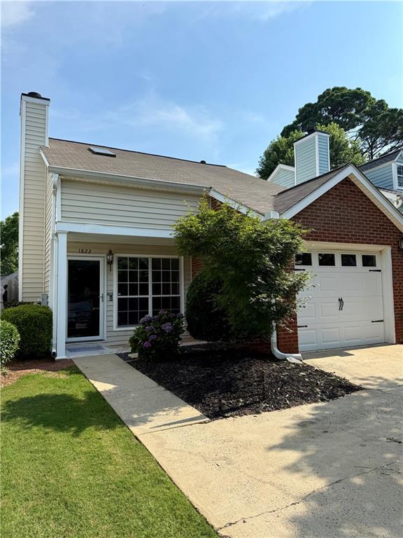 1822 Commonwealth Dr, Woodstock, GA 30188 - view of front of property featuring a chimney, a garage, driveway, and brick siding