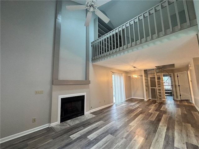 1822 Commonwealth Dr, Woodstock, GA 30188 - unfurnished living room featuring stairs, a fireplace with flush hearth, plenty of natural light, wood finished floors, and a high ceiling