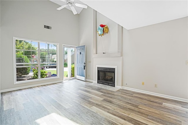 1822 Commonwealth Dr, Woodstock, GA 30188 - unfurnished living room with high vaulted ceiling, wood finished floors, a fireplace, and ceiling fan