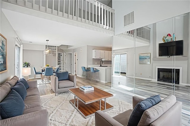 1822 Commonwealth Dr, Woodstock, GA 30188 - living room featuring light wood-style floors, a high ceiling, and a fireplace with flush hearth