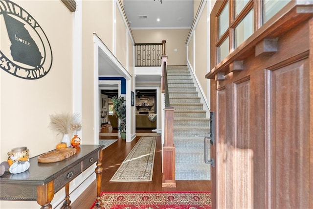 foyer with ornamental molding and dark wood-type flooring