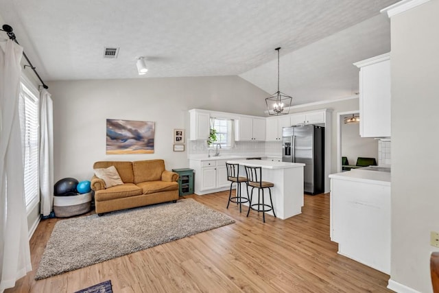 2780 Matlin Way, Buford, GA 30519 - living area featuring vaulted ceiling, light wood-style flooring, a textured ceiling, and a chandelier