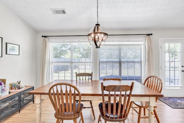 2780 Matlin Way, Buford, GA 30519 - dining space featuring a chandelier, light wood-type flooring, and a textured ceiling