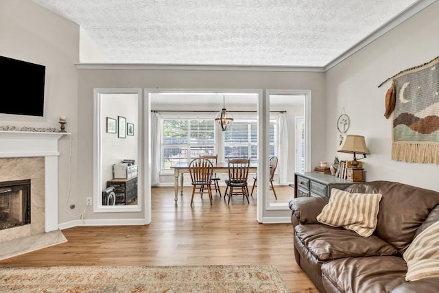 2780 Matlin Way, Buford, GA 30519 - living area featuring wood finished floors, a textured ceiling, a high end fireplace, baseboards, and a chandelier