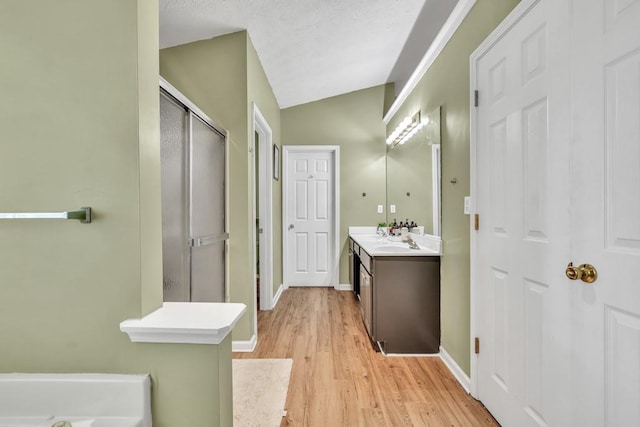 2780 Matlin Way, Buford, GA 30519 - bathroom featuring a stall shower, vanity, vaulted ceiling, wood finished floors, and baseboards