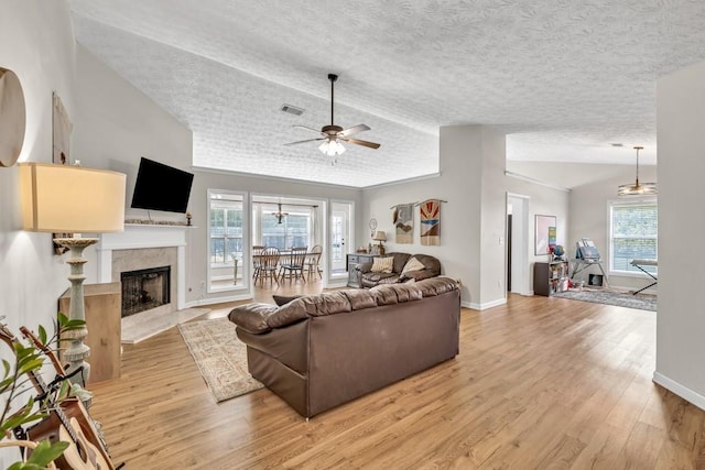 2780 Matlin Way, Buford, GA 30519 - living area featuring vaulted ceiling, a textured ceiling, light wood finished floors, a fireplace, and ceiling fan
