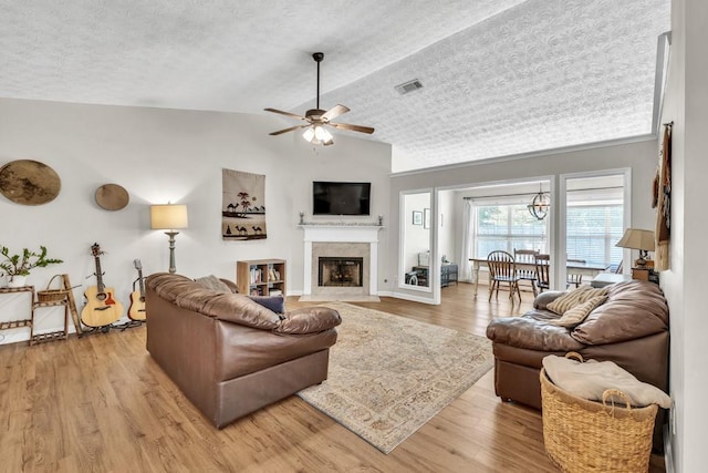 2780 Matlin Way, Buford, GA 30519 - living area featuring lofted ceiling, light wood-style flooring, a high end fireplace, a ceiling fan, and a textured ceiling