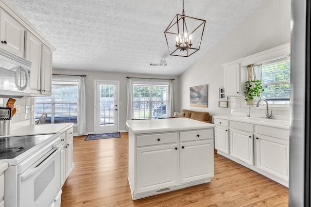 2780 Matlin Way, Buford, GA 30519 - kitchen featuring a textured ceiling, light wood finished floors, white appliances, a center island, and a sink