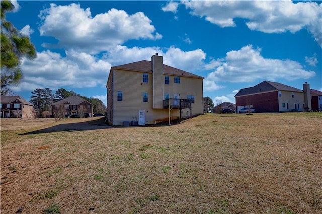 rear view of property with a residential view, a lawn, and a chimney