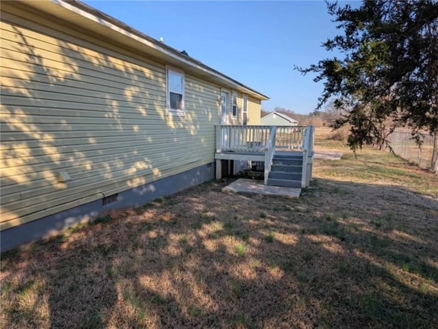 view of side of property with a wooden deck and a lawn