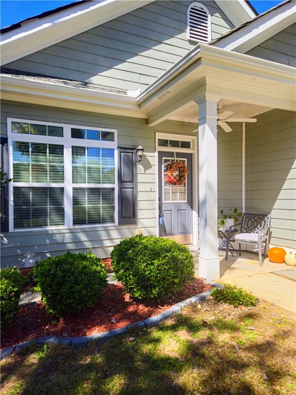 view of exterior entry featuring ceiling fan