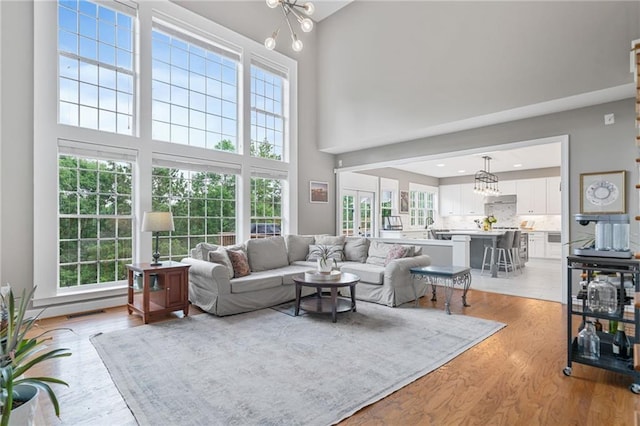 1775 Porterton Way, Cumming, GA 30041 - living area with a chandelier, light wood-style flooring, and a high ceiling