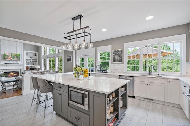 1775 Porterton Way, Cumming, GA 30041 - kitchen with appliances with stainless steel finishes, gray cabinets, open shelves, open floor plan, and light stone countertops