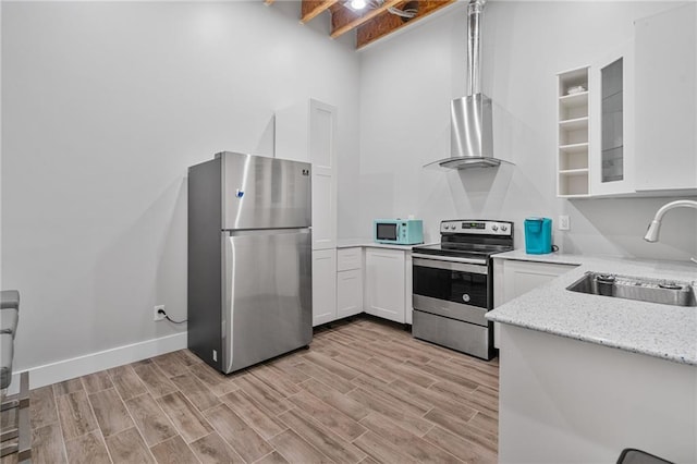 1775 Porterton Way, Cumming, GA 30041 - kitchen featuring appliances with stainless steel finishes, wall chimney range hood, white cabinetry, and light wood finished floors