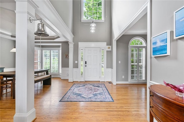 1775 Porterton Way, Cumming, GA 30041 - entryway with ornate columns, healthy amount of natural light, a towering ceiling, light wood-style flooring, and wainscoting