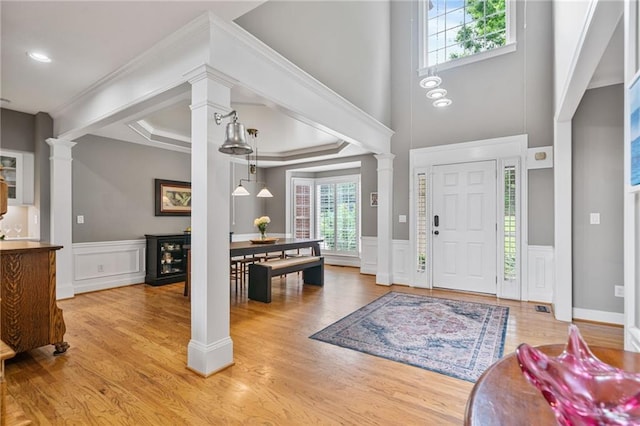 1775 Porterton Way, Cumming, GA 30041 - entrance foyer featuring decorative columns, a decorative wall, plenty of natural light, light wood finished floors, and a wainscoted wall