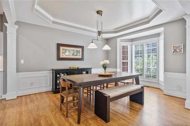 1775 Porterton Way, Cumming, GA 30041 - dining space with decorative columns, a raised ceiling, light wood-type flooring, wainscoting, and a decorative wall