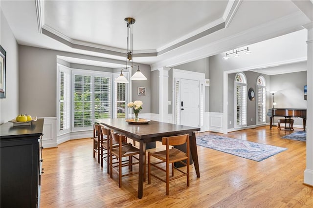 1775 Porterton Way, Cumming, GA 30041 - dining room featuring decorative columns, a raised ceiling, crown molding, light wood-type flooring, and wainscoting