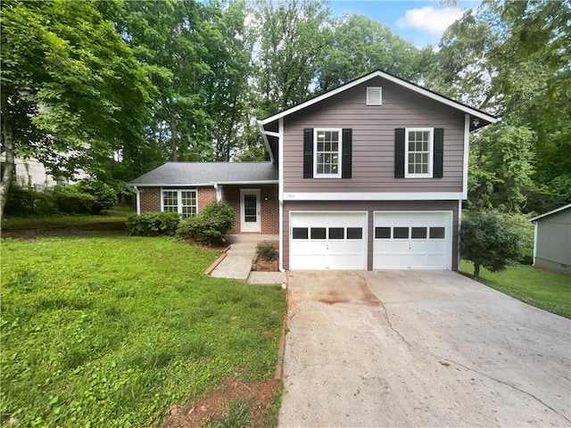 split level home with an attached garage, concrete driveway, a front yard, and brick siding