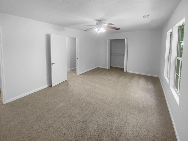 unfurnished bedroom with carpet floors, a closet, baseboards, and a ceiling fan