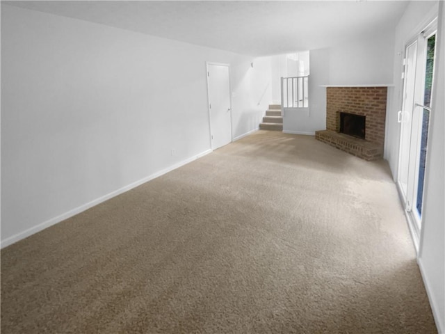 unfurnished living room featuring light colored carpet, stairway, a fireplace, and baseboards