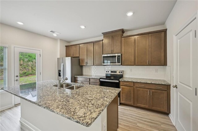 2770 Aralynn Way, College Park, GA 30337 - kitchen featuring a kitchen island with sink, stainless steel appliances, visible vents, backsplash, and light wood-style flooring