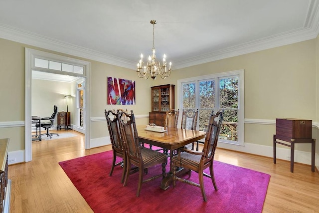 dining room featuring ornamental molding, light hardwood / wood-style flooring, and an inviting chandelier