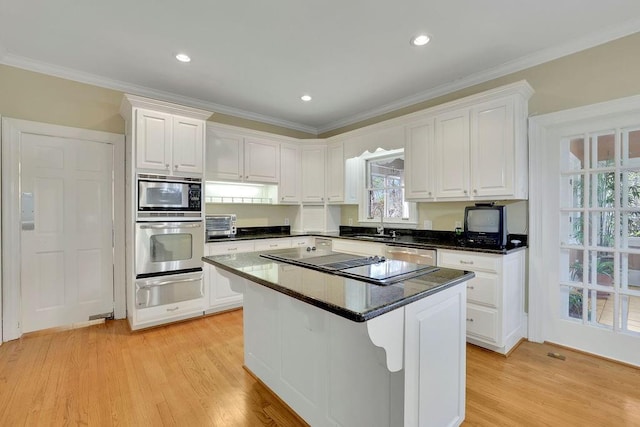 kitchen featuring crown molding, white cabinetry, a center island, and stainless steel appliances